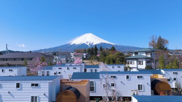 A row of modern, single-story mobile homes with a view of Mount Fuji in the background.