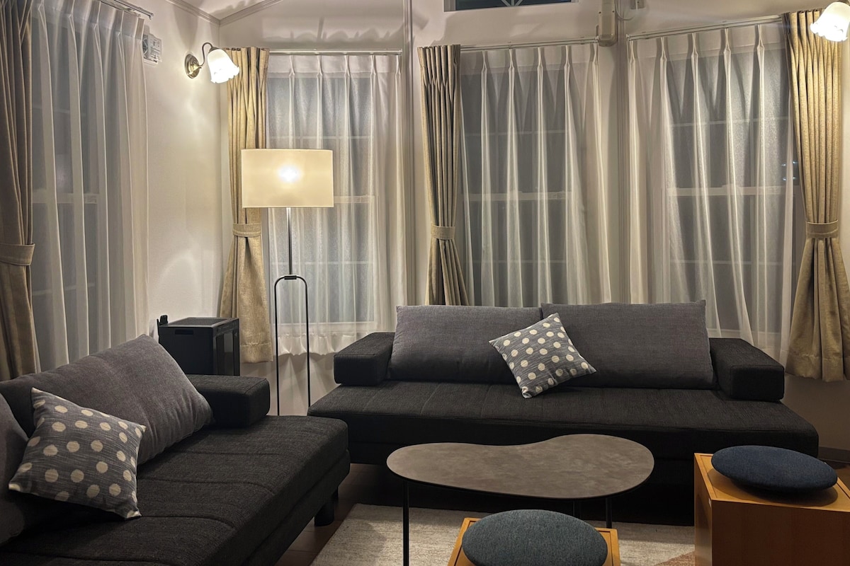 A modern living room with a sofa, a coffee table, and a lamp.