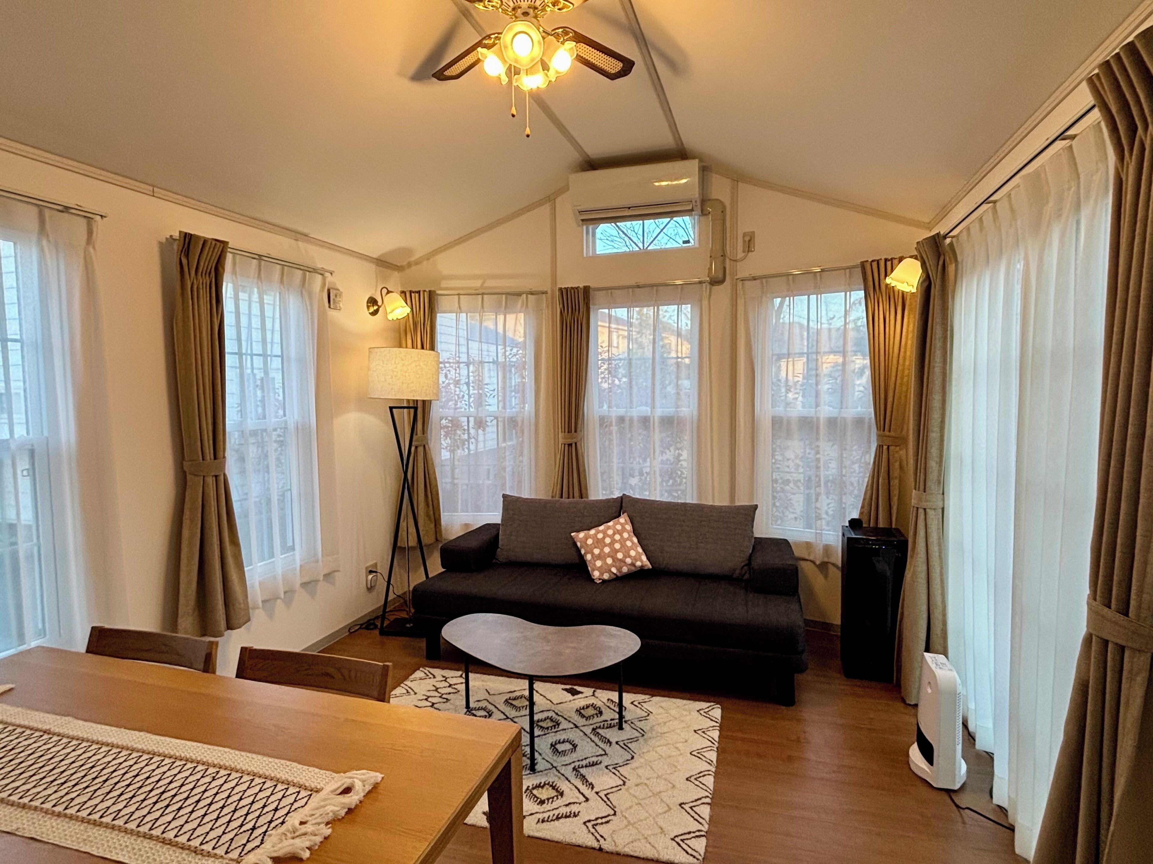 Een moderne woonkamer met een bank, een salontafel en een eethoek met een tafel en stoelen.