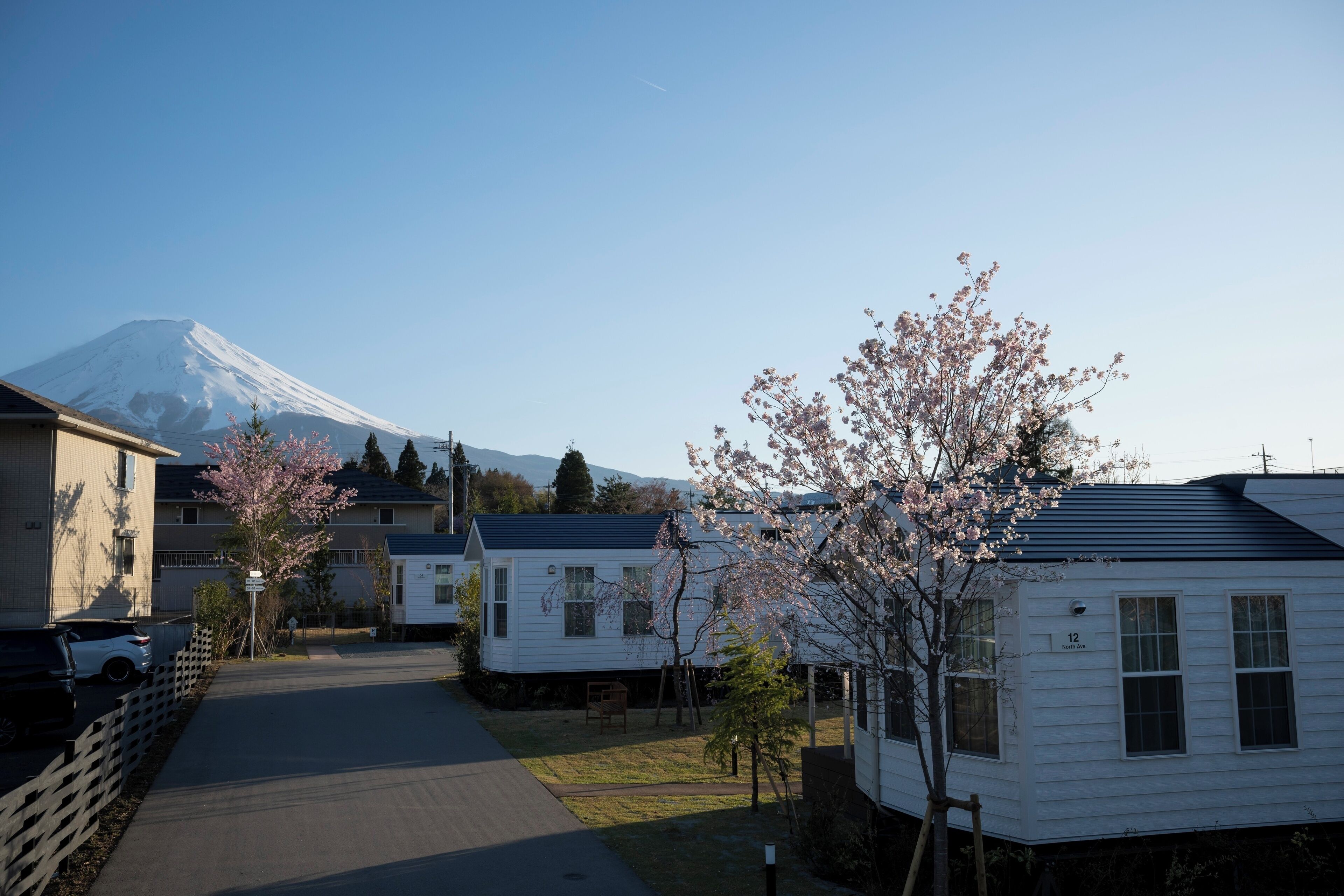 A row of white mobile homes with a clear view of Mount Fuji in the background.