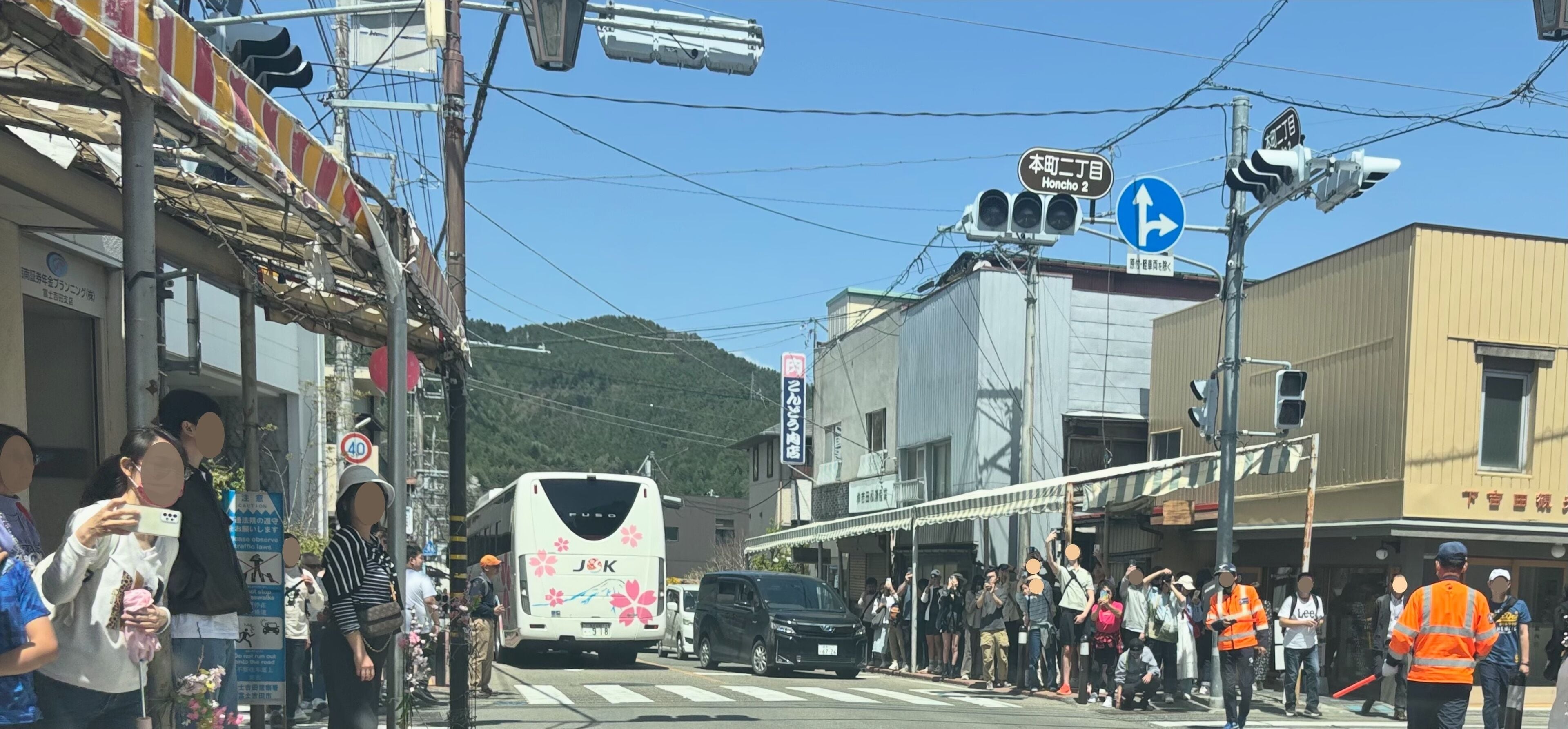 A street scene with a bus, pedestrians, and buildings.