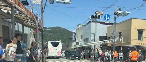 A street scene with a bus, pedestrians, and buildings.