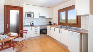 A modern kitchen with white cabinets, a stainless steel sink, and a Bosch dishwasher. - Holidays in Mallorca: renovated apartment with sea views (Portocolom)