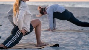 Two individuals practicing yoga on a beach with the ocean in the background. - Holiday Home With sea View in Ustronie Morskie (Ustronie Morskie)