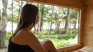 A person sitting by a window with a view of trees. - Holiday Home With sea View in Ustronie Morskie (Ustronie Morskie)