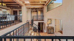 Un interior espacioso con techo de madera, una escalera y un comedor.
