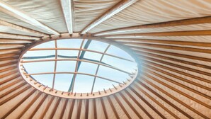 A circular skylight with wooden beams radiating outward. - Willow Yurt - UKC6947 (Beaminster)