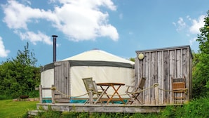 En yurt med en træterrasse, et bord og to stole.