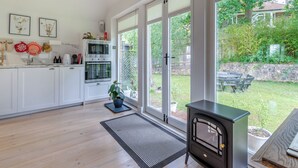 A modern kitchen with white cabinets, stainless steel appliances, and large windows. - Fir Tree Apartment - UK49993 (Crowborough)