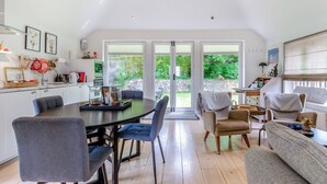 A spacious kitchen with a dining area, large windows, and a cozy seating area. - Fir Tree Apartment - UK49993 (Crowborough)