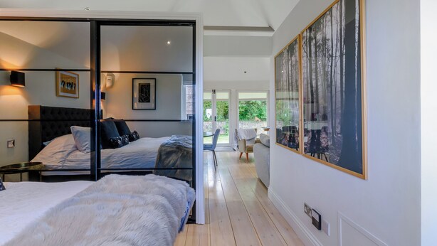 A modern bedroom with two beds, a large window, and a painting on the wall. - Fir Tree Apartment - UK49993 (Crowborough)