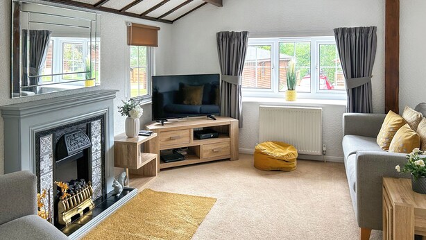 A living room with a fireplace, TV, sofa, and a yellow bean bag.