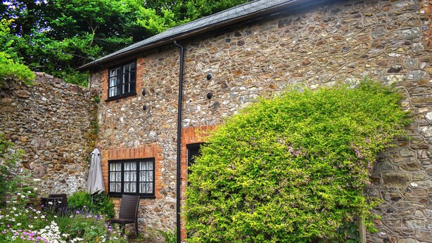 Ein Steinhaus mit einem Garten davor.