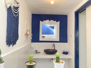 A bathroom with a white sink, blue accent wall, and a mirror above it. - Lovys Gili Air (Gili Air)