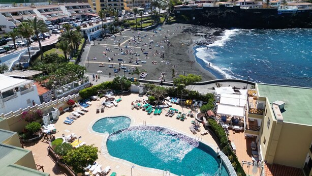 A resort with a large pool, beach, and ocean views.