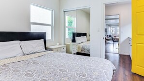 Un dormitorio con cama, mesitas de noche, un espejo y un armario.