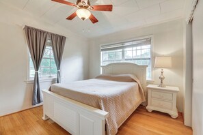 A bedroom with a bed, a nightstand, a ceiling fan, and a window with curtains. - Boat Lift & Private Dock: Riverfront LaBelle Gem (LaBelle)