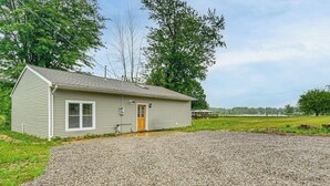 Une maison de plain-pied avec une allée en gravier et un petit jardin devant.