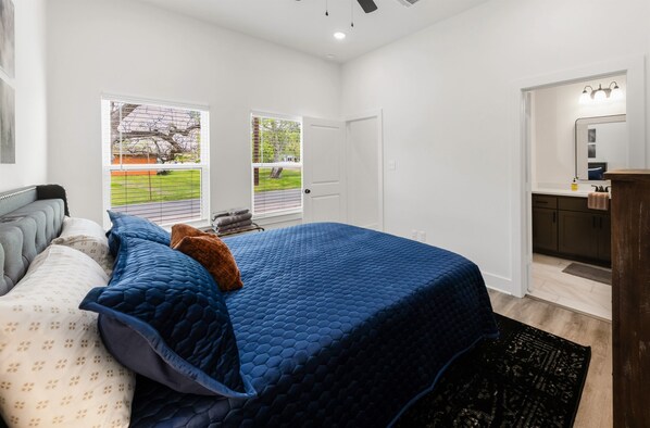 A bedroom with a large bed, a dresser, a mirror, and a door leading to a bathroom. - Ranger: New Home, 2mi-A&M/Walk-Legends Event Ctr (Bryan)