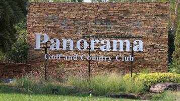 A stone wall with the text "Panorama Golf and Country Club" indicating the name of the establishment.
