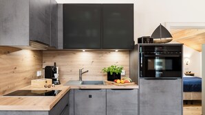 Een moderne keuken met een houten aanrecht, een inbouwoven en een spoelbak.