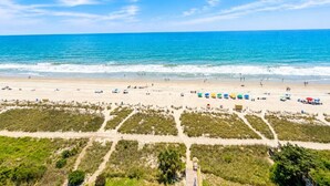 A beach with clear skies, a sandy shore, and a few umbrellas. - Atlantic Lux. Spacious relax. (Myrtle Beach)