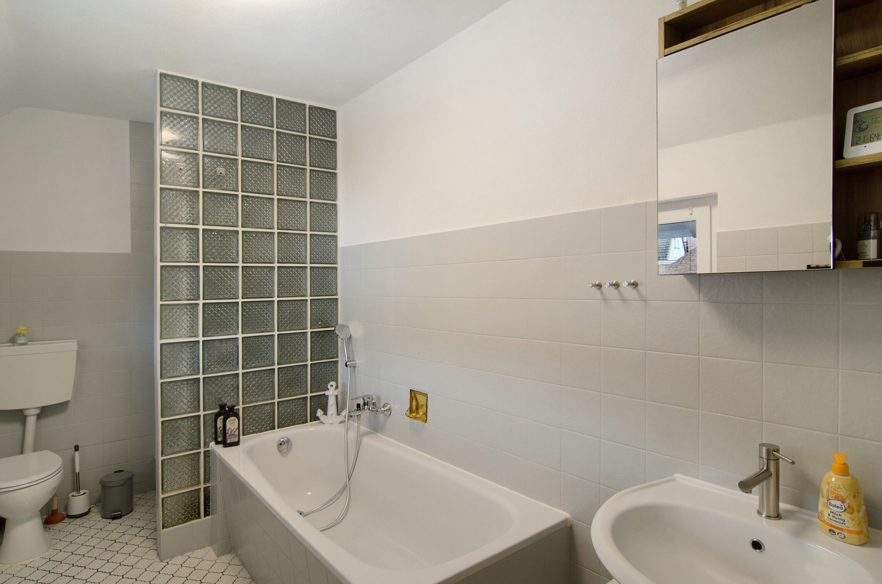 Een badkamer met een bad, wastafel en toilet.