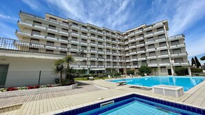 Un hôtel à plusieurs étages doté d’une piscine, d’un espace extérieur aménagé et d’un jardin paysager.