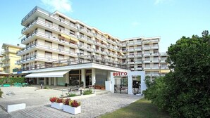Un hôtel à plusieurs étages doté de balcons, d’une cour intérieure et d’un restaurant appelé « Astro ».