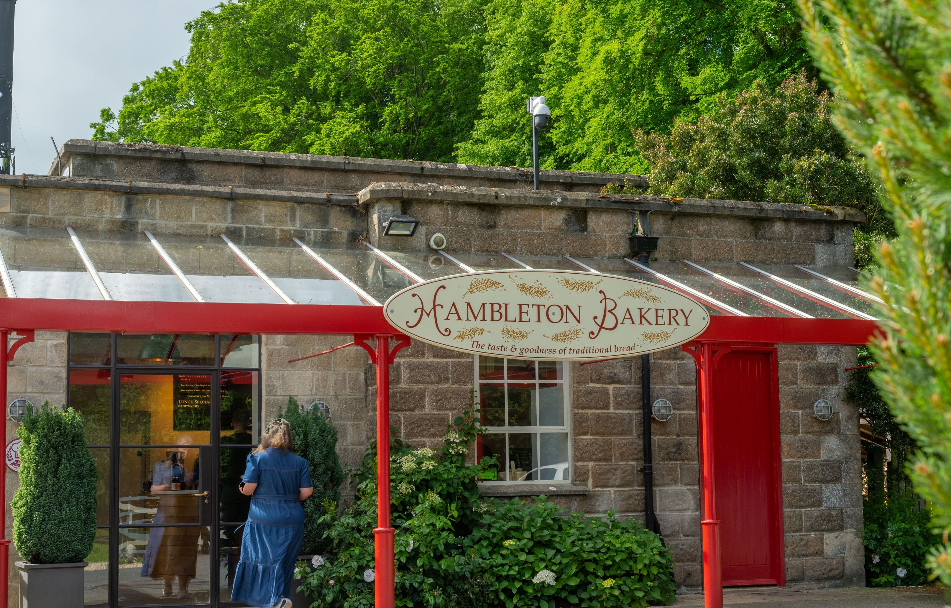 Ein traditionelles Steinhaus mit rotem Markisen und einem Schild, auf dem "Hambleton Bakery" steht.