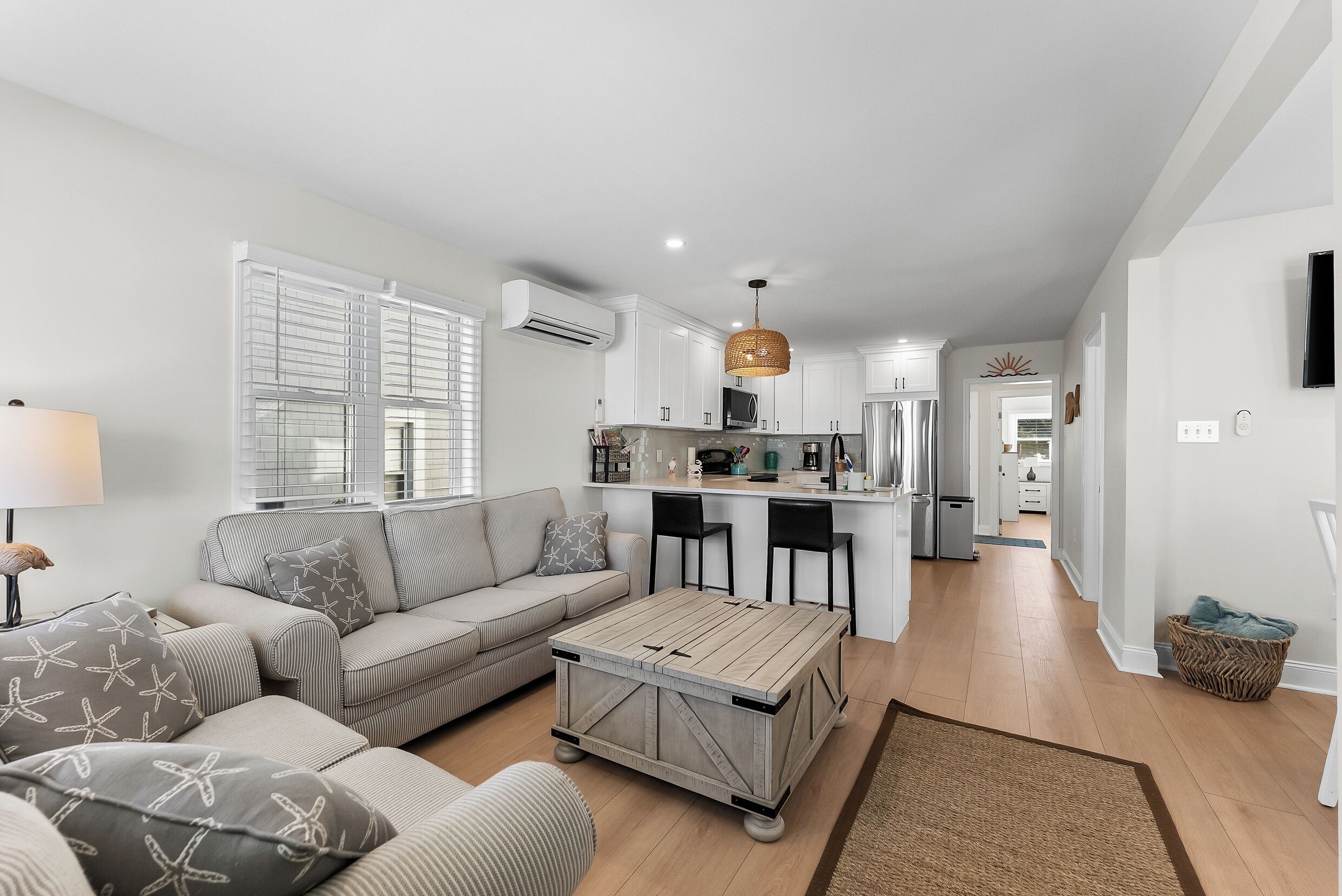 A modern living room with a sofa, coffee table, and a dining area with chairs.