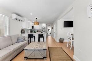 A modern kitchen with white cabinets, a central island, and a hanging light fixture.