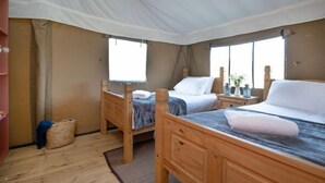 A room with two wooden beds, a window, and a small table. - Nuthatch at Kittisford Barton in Somerset with hot tub (Wellington)
