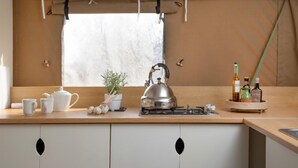 A kitchen with a stove, kettle, and various kitchen items on the counter. - Nuthatch at Kittisford Barton in Somerset with hot tub (Wellington)