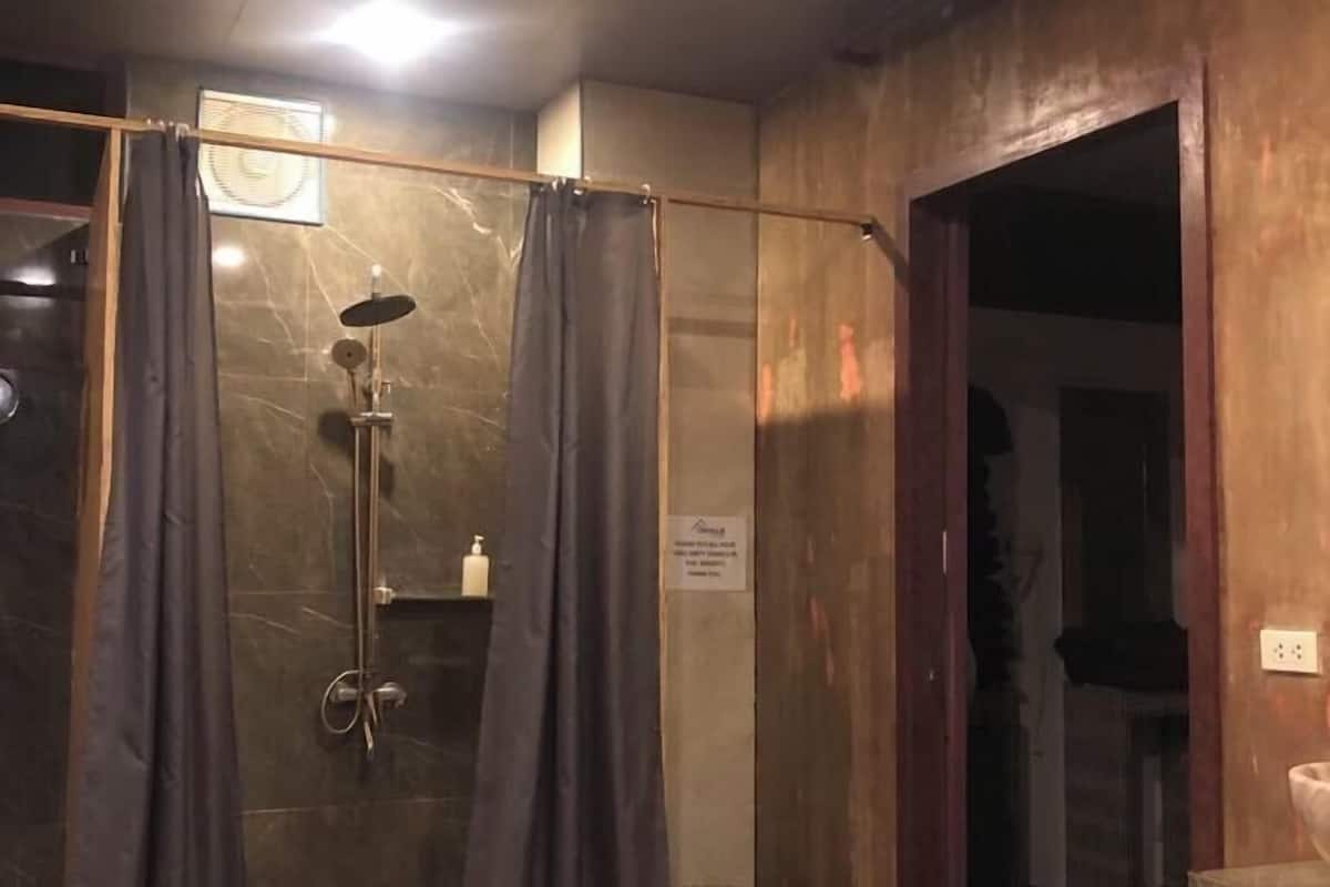 A bathroom with a shower, a toilet, and a sink.