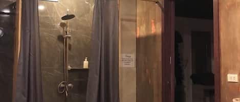 A bathroom with a shower, a toilet, and a sink.