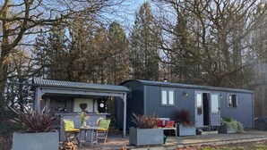 A modern, compact mobile home with a covered patio area, outdoor seating, and a fire pit. - Top Farm Shepherds Lodge, nestled in a peaceful farm in Marsham, North Norfolk (Marsham)