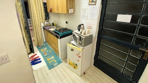 Une cuisine compacte équipée d’une cuisinière, d’un four à micro-ondes et d’un réfrigérateur.