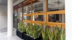 Une entrée moderne, avec de grandes fenêtres, un pilier blanc et des plantes en pot.