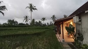 A house with a covered porch and a garden. - Rumah Kemuning Bali (Bali)