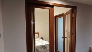 A bedroom with a bed, a nightstand, and a mirror. - Rumah Kemuning Bali (Bali)