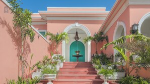 A building with a pink facade, a turquoise door, and a fountain in the center. - Dolce Vita - Luxury Vacation Villas (Pushkar)