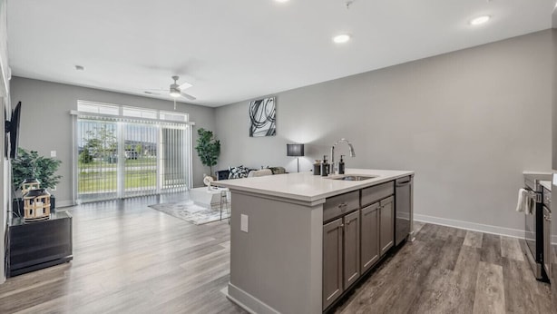A modern kitchen with a large island, grey walls, and a sliding glass door leading to a patio. - Work + Relax | Luxury Escape (Whitestown)