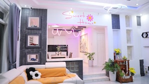 A modern living room with a sofa, a coffee table, and a decorative plant. - 7 bedroom villa Flamingo Danang (Da Nang)