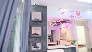 A modern hotel interior with a reception area, a sign reading "Sweet Home," and a dining area visible through the doorway. - 7 bedroom villa Flamingo Danang (Da Nang)