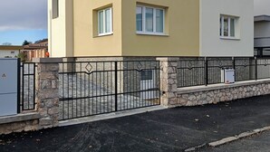 A multi-story residential building with a beige facade, multiple windows, and a stone base. - Spacious 2-bedroom apartment in Lučenec (Banskobystrický kraj)