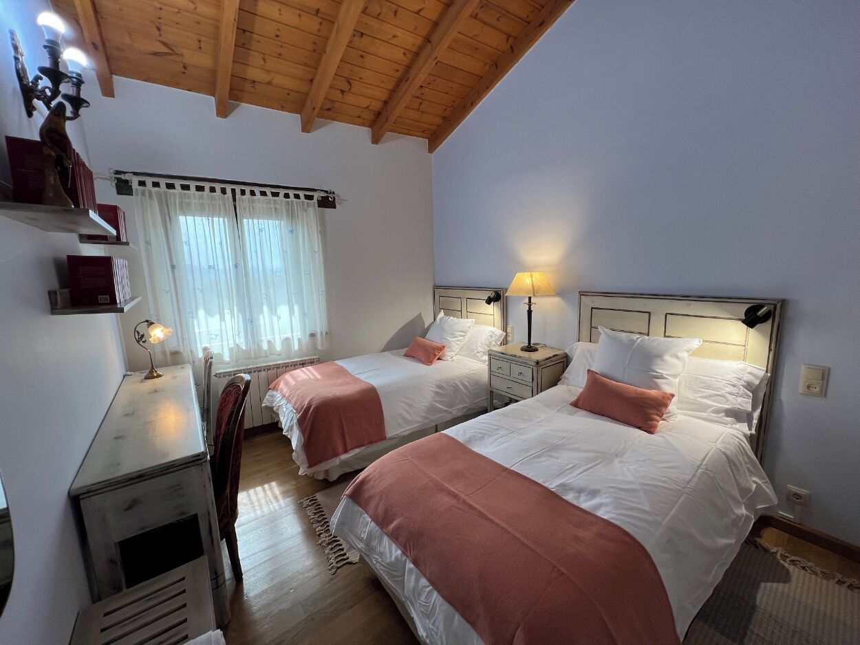 Een kamer met twee bedden, een bureau en een stoel.