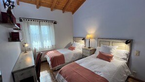 A room with two beds, a desk, and a chair.