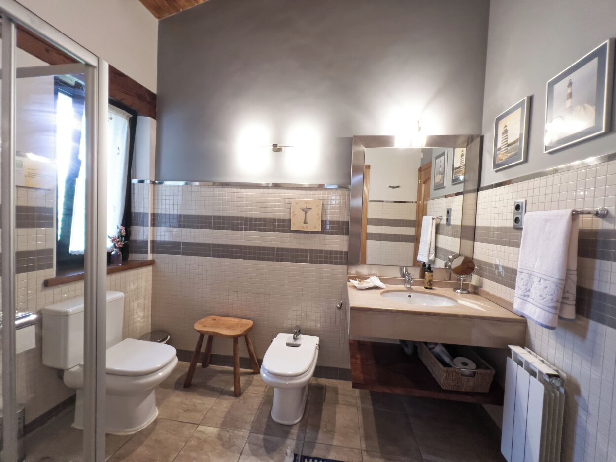 A modern bathroom with a toilet, bidet, and sink.