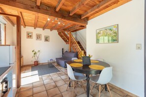 A dining area with a table, chairs, and a chalkboard sign. - Holiday Home “Gîte Lieuj” with Mountain View, Private Terrace, and Wi-Fi (Peyrouse)